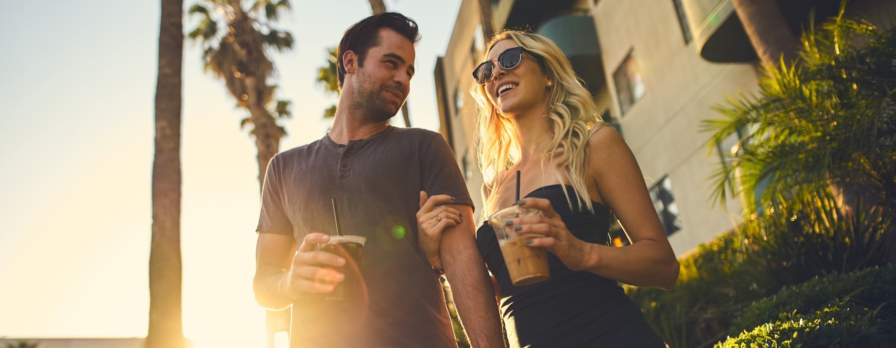 a couple walking and holding drinks