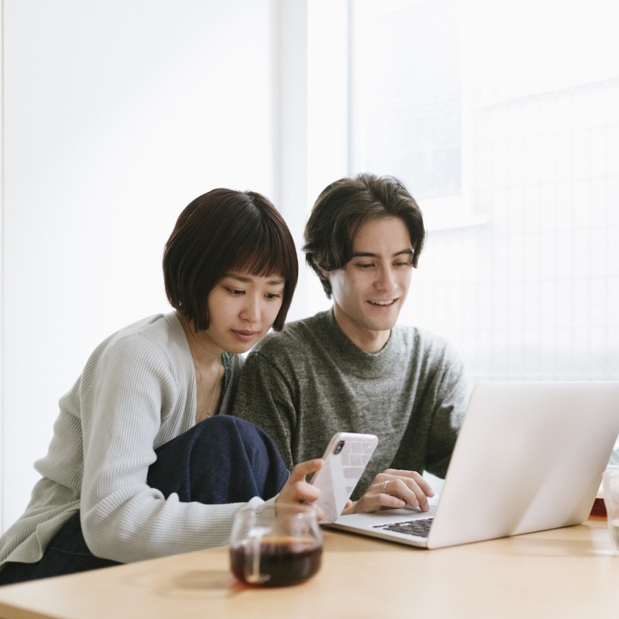 a couple sitting at a table with a comouter