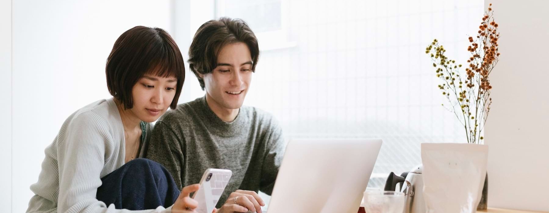 a couple sitting at a table with a comouter
